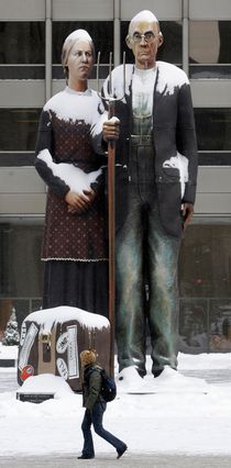 This is an image of a statue version of the painting 'American Gothic,' on display in a snowy Chicago in 2009.